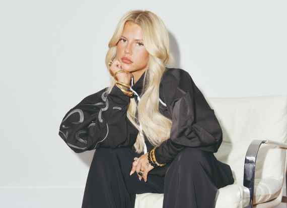 Skye Newman, british singer-songwriter, sitting on a chair